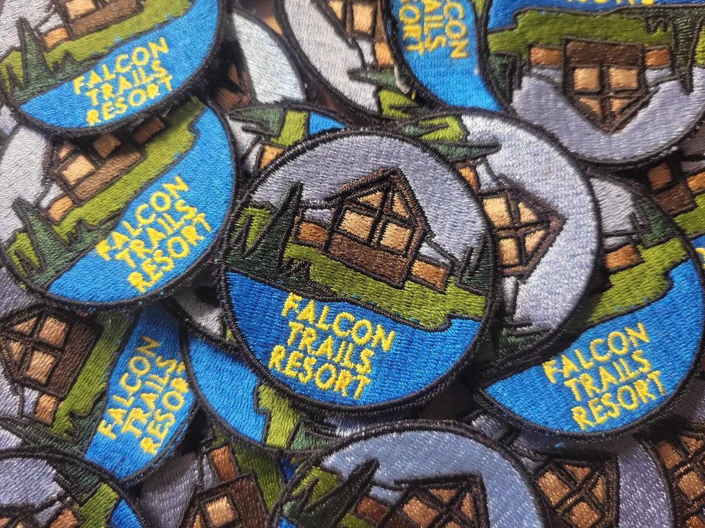 Pile of Falcon Trails Resort embroidered patches.