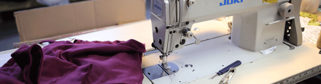 Sewing machine with maroon garment.