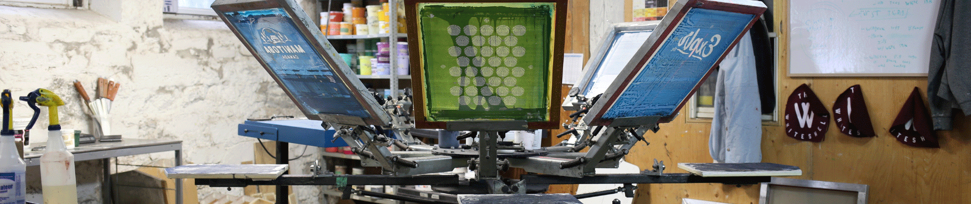 Proper Designworks Screen printing machine with blue and green screens.