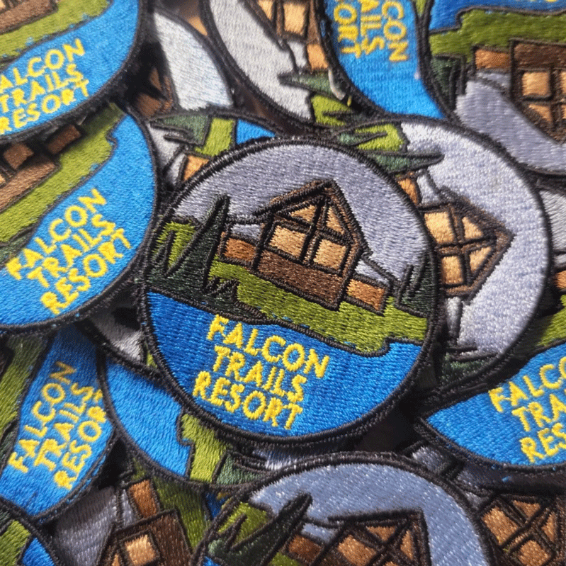 Pile of Falcon Trails Resort embroidered patches.
