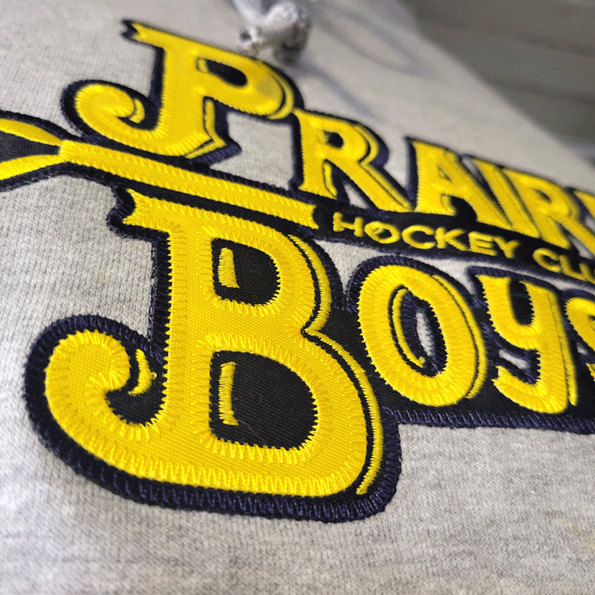 Prairie Boys Hockey Club large embroidered patch on grey hoodie.