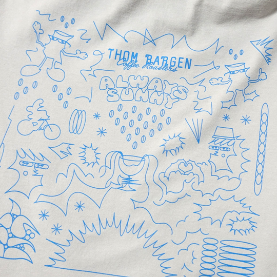 Blue 'Thom Bargen Coffee Roasters Always Sunny ' graphic on white fabric.
