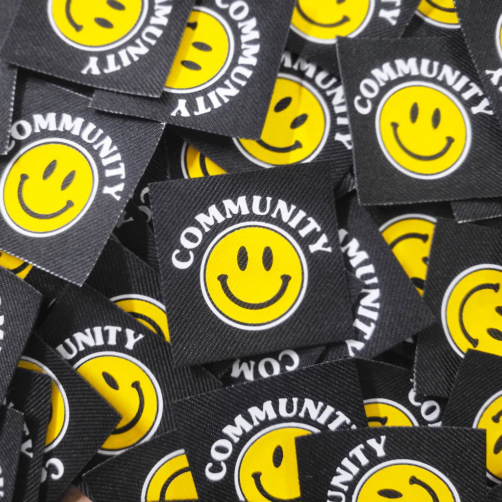 Pile of Community with a smily face graphic vinyl tags.