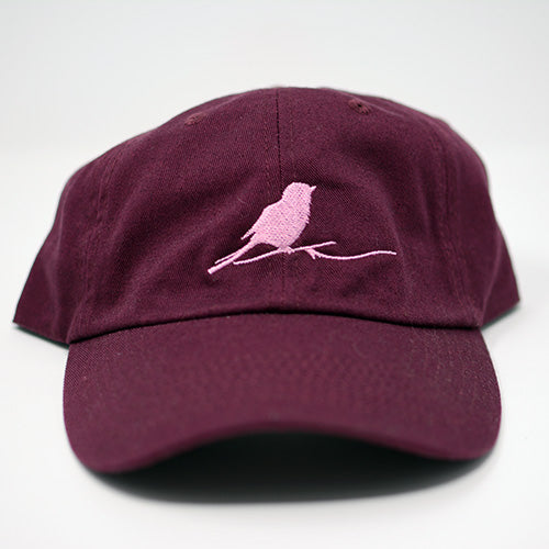Maroon cap with pink embroidered bird on white background.